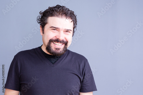 Smiling Man Wearing Black T-Shirt in Gray Studio