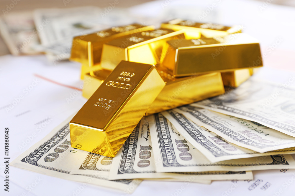 Gold bars with dollar banknotes on paper background Gold bars with dollar banknotes on paper background