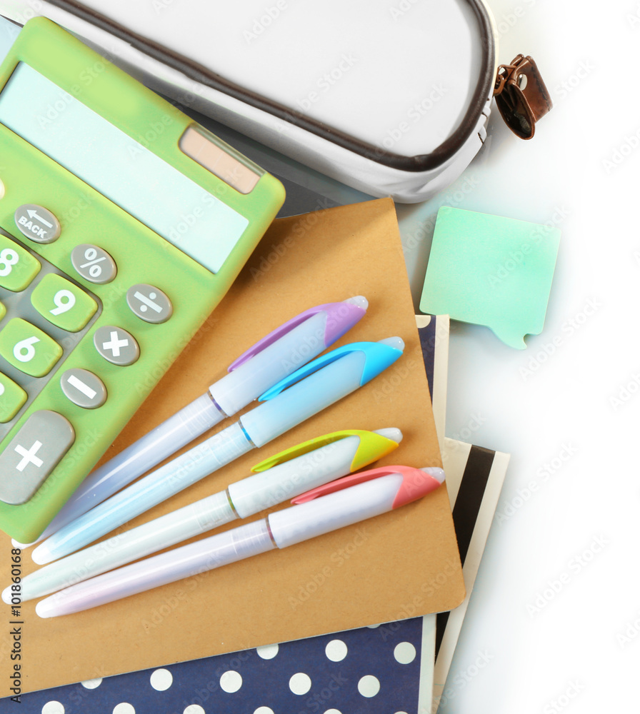 A pile of stylish notebooks and stationary, isolated on white background A pile of stylish notebooks and stationary, isolated on white background