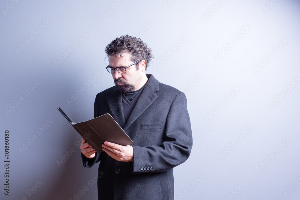 Businessman Wearing Glasses Reading from Tablet