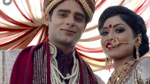 Shot of Indian bride and groom in traditional wedding dress under a mandap photo