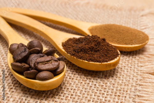 Grains, ground and instant coffee with wooden spoon on jute canvas