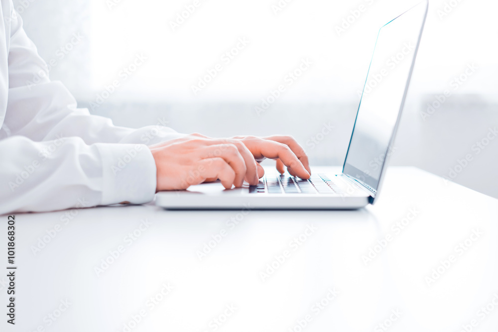 Man's hands using laptop in office on desk Man's hands using laptop in office on desk