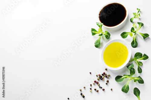 Healthy food background with olive oil, balsamic, cornsalad and colorful spices on white backdrop.Detox and diet concept. 