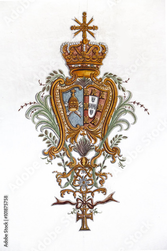 Obidos, Portugal. Baroque fresco of the Portuguese Royal Coat of Arms with Vatican emblem in Sao Pedro Church. Obidos is a medieval town inside walls, and very popular among tourists. photo