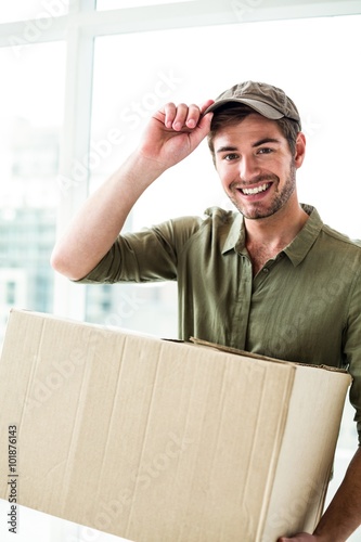 Smiling postman holding package  photo