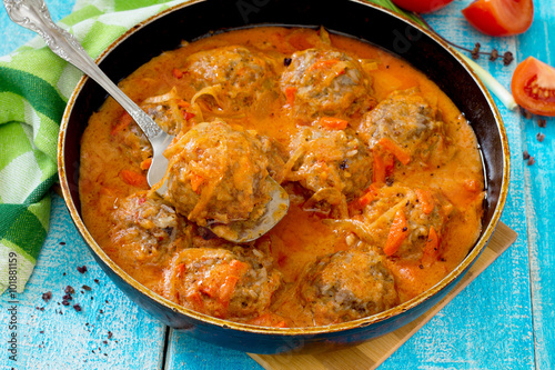 Homemade meatballs in tomato sauce with spices in a rustic style