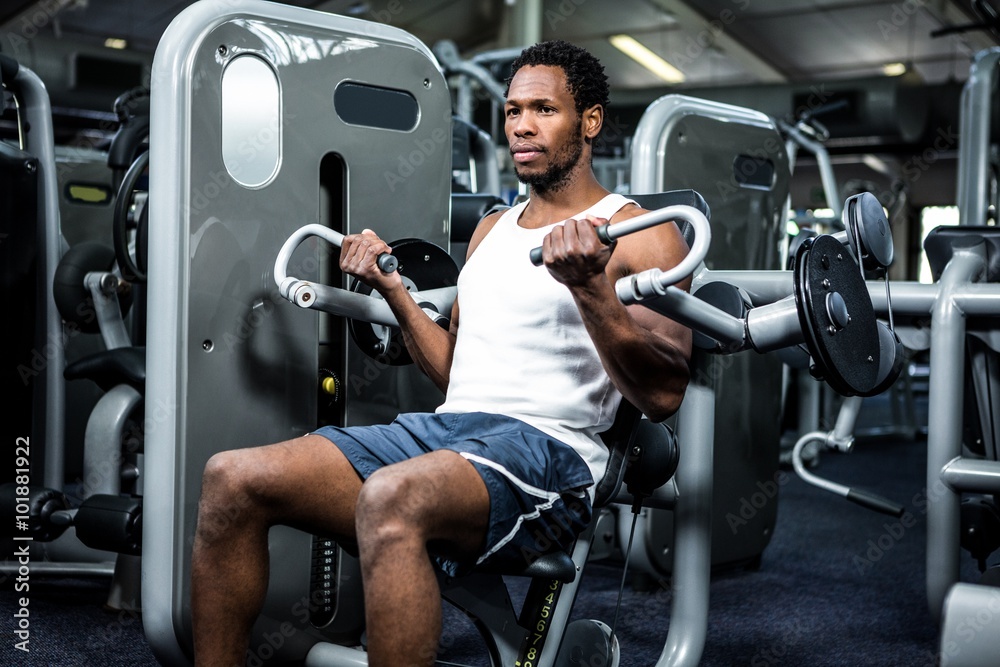 Serious muscular man using exercise machine Serious muscular man using exercise machine