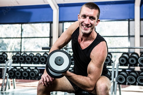 Muscular man exercising with dumbbells 