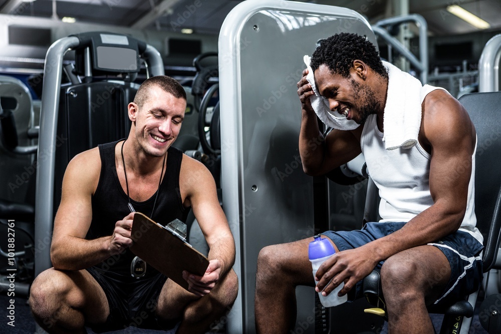 Fotografie Muscular man discussing performance with trainer