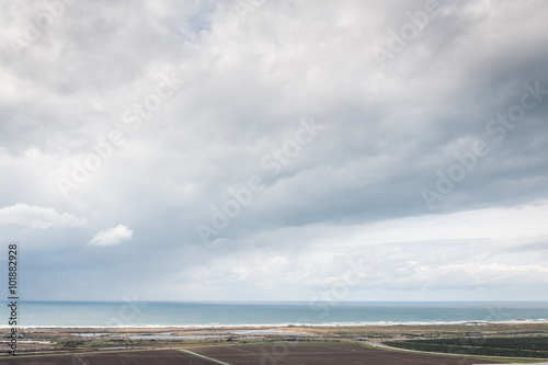 view of landscape with the sea  fiedls and clouds
