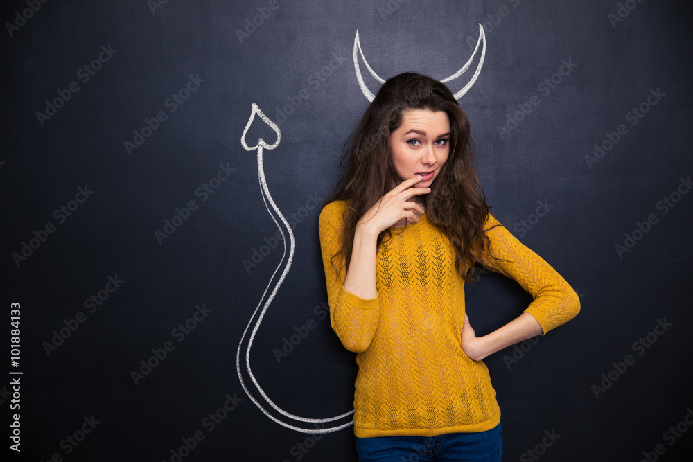 Pensive playful woman thinking over chalkboard background
