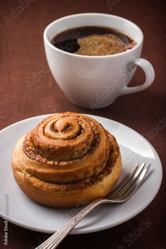 cinnamon roll bun  and cuf of coffee