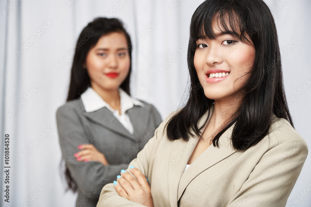 close up of businesswomen wearing suits standing and folding arms
close up of businesswomen wearing suits standing and folding arms