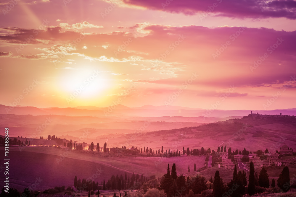 Obraz premium Wonderful Tuscany landscape with cypress trees, farms and medieval towns, Italy. Pink and purple sunset
