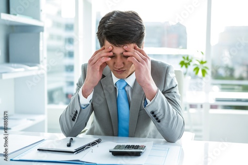 Troubled asian businessman in his desk