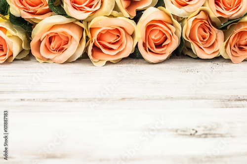 Pink roses on rustic wood background. Flowers background with copy-space useful as greetings card