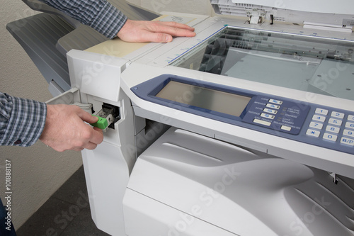 Midsection of businessman fixing cartridge in photocopy machine