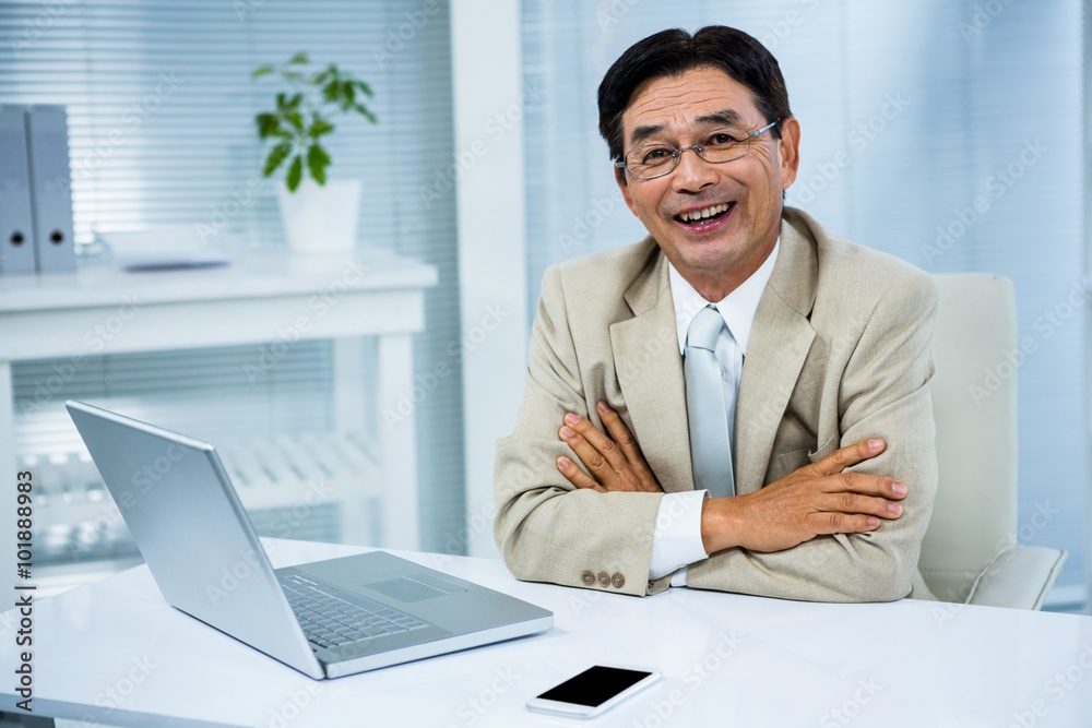 Smiling businessman with crossed arms