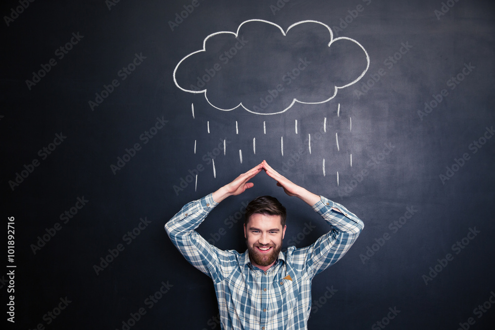 Man imitating roof with hands and covering from drawn rain