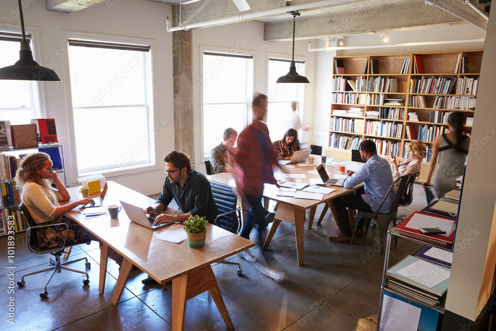 Overhead View Of Businesspeople Working At Desks In Office Overhead View Of Businesspeople Working At Desks In Office