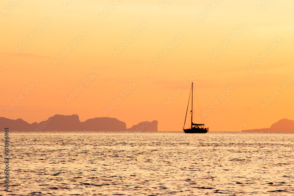 Sailboat on the ocean at  sunset