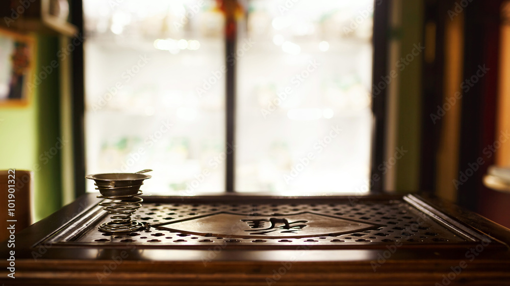 Tea shop with blurred background, tray for traditional ceremony, interior. Shallow depth of field. Metal cup on a spring. Tea shop with blurred background, tray for traditional ceremony, interior. Shallow depth of field. Metal cup on a spring.