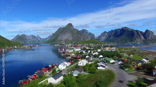 Aerial view of picturesque norwegian fishing town Reine on Lofoten islands, surrounded by fjords and mountain peaks, popular tourist destination. Aerial 4k Ultra HD.