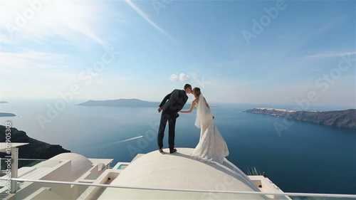 Happy married couple kissing on terrace with sea background, Santorini closeup