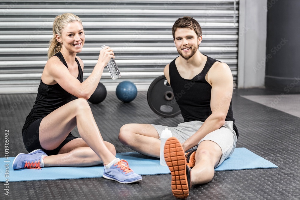 Fototapeta premium Couple sitting on fitness mat