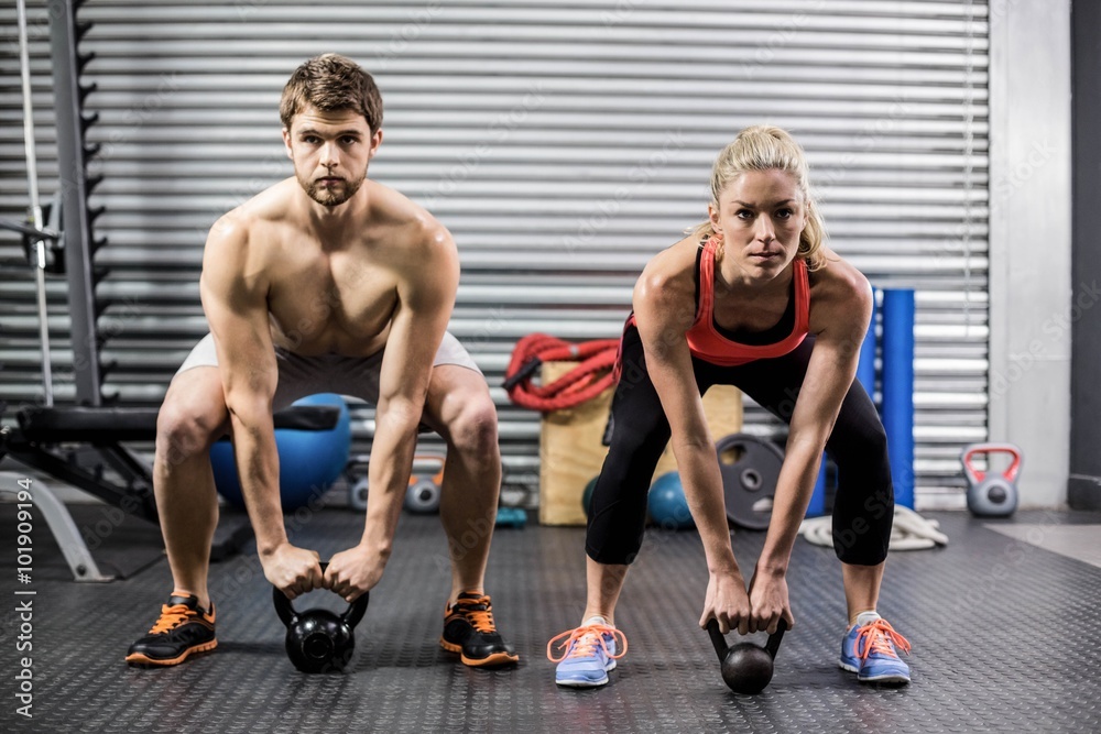 Fotografie Couple lifting dumbbells together