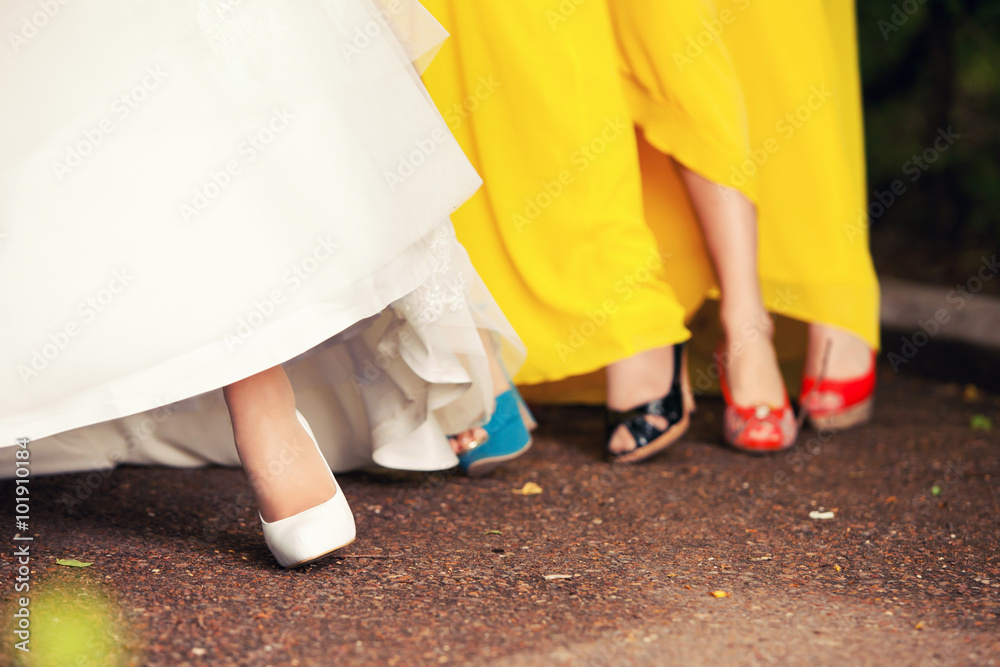 bride's foot in shoes and bridesmaids