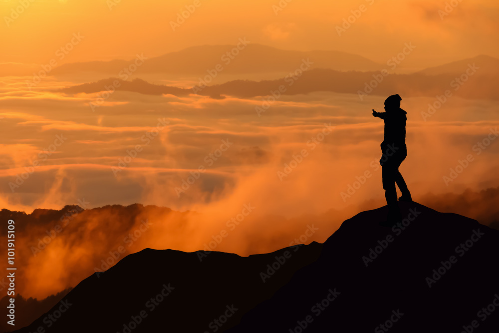 Silhouette of man standing on the top of mountain