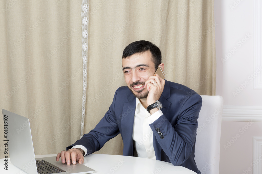 Naklejka premium Portrait of a man with a laptop. A man sits at a Desk and working. 