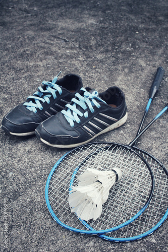 Sport shoes with shuttlecocks and badminton racket.