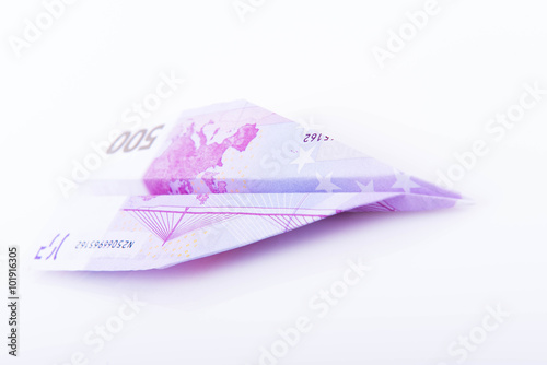 Paper plane made with a 500 euro note on white background