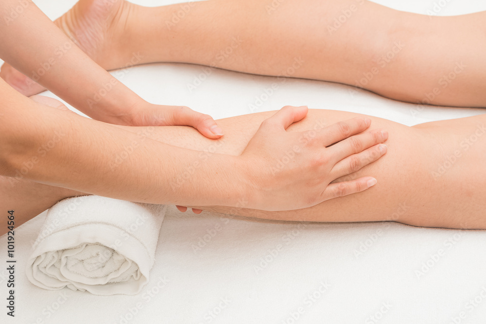 Therapist doing massage on woman leg in day spa Therapist doing massage on woman leg in day spa