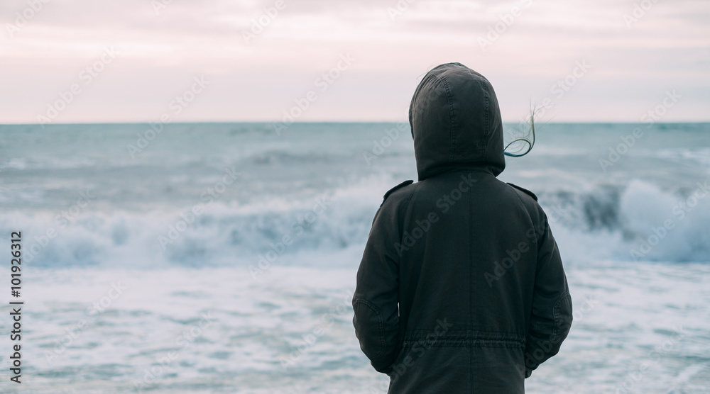 Woman looking at sea waves - obrazy, fototapety, plakaty 