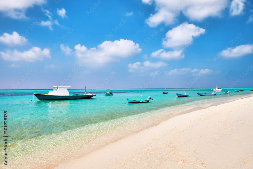 Shoreline of a tropical island with boat in the Maldives and vie