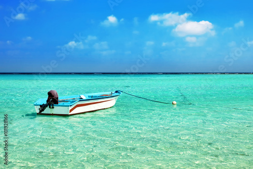 Shoreline of a tropical island with boat in the Maldives and vie