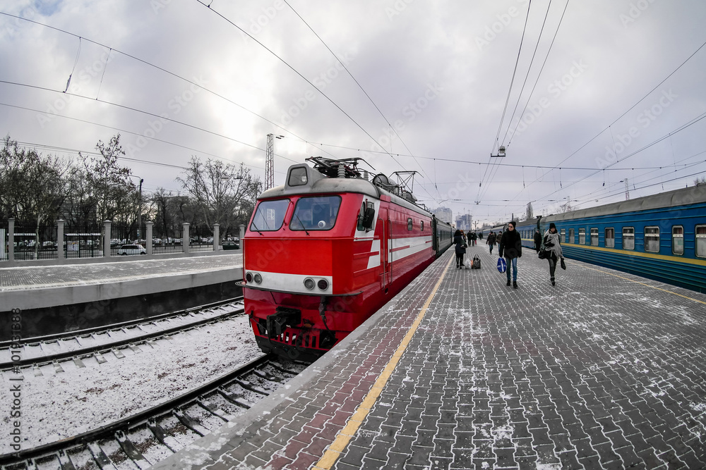 red locomotive on train station platform in the winter