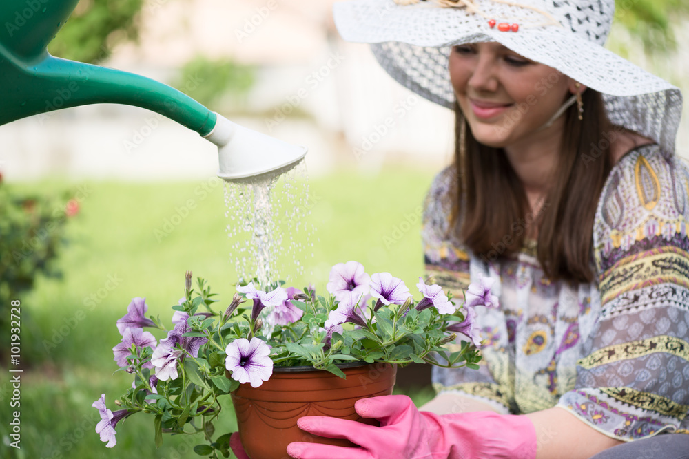 Fototapeta premium Young pretty mother and her little son gardening in front or back yard.