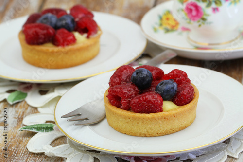 Cream cakes with fresh raspberries and blueberries
