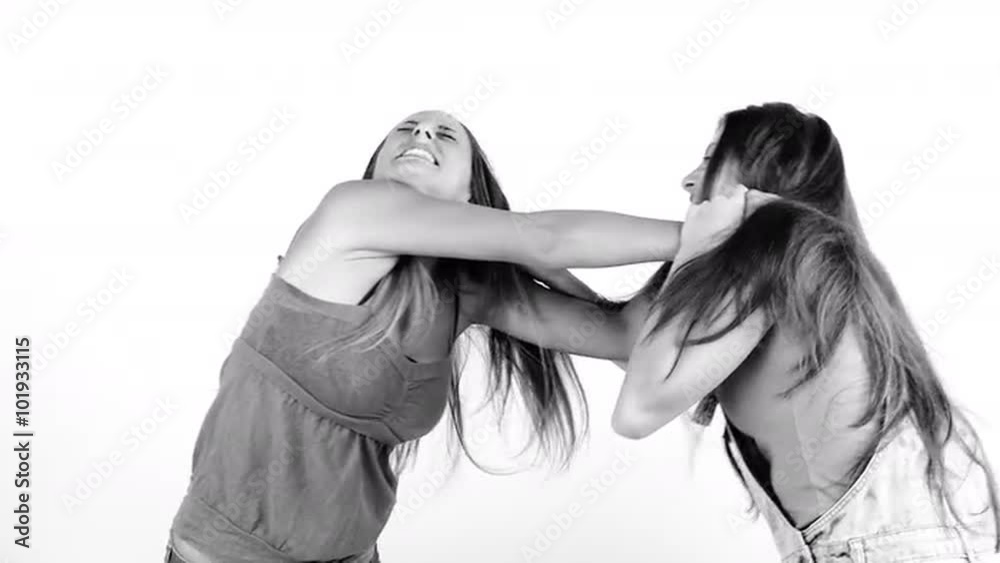 Two girls fighting pulling strong long hair black and white isolated