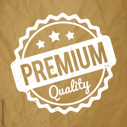 Premium Quality rubber stamp white on a crumpled paper brown background.