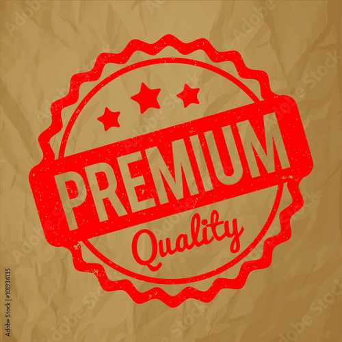 Premium Quality rubber stamp red on a crumpled paper brown background.