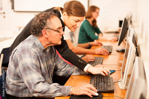 Group of adults learning computer skills. Intergenerational tran