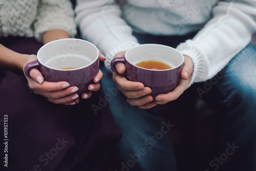 couple holding cups of tea