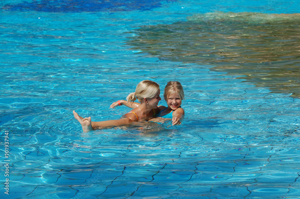Mother and daughter laughing in the pool