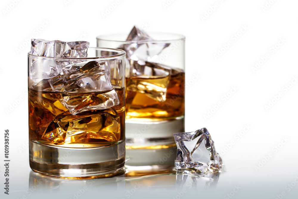 Two glasses of scotch whiskey with ice cubes, on white Two glasses of scotch whiskey with ice cubes, on white